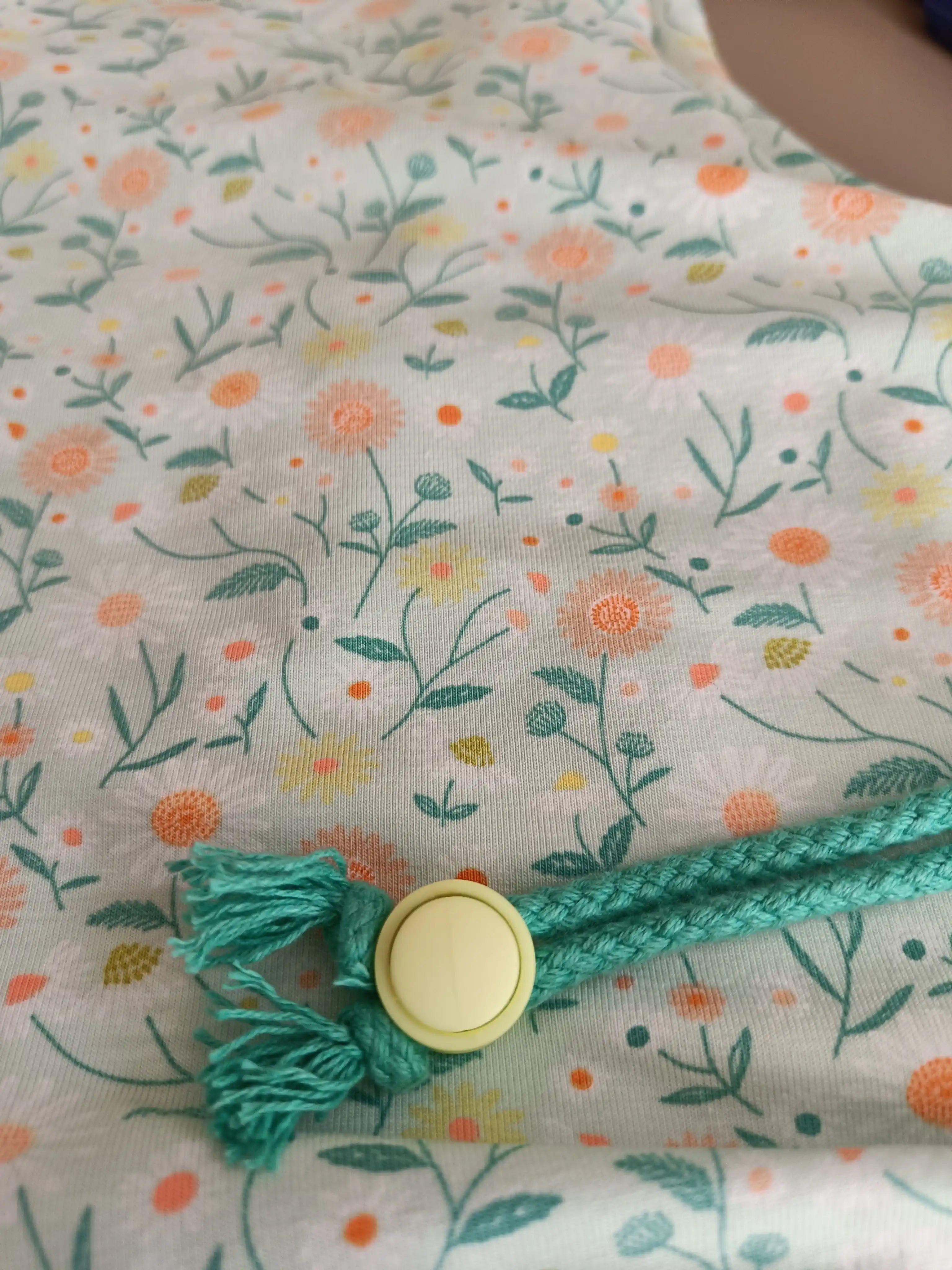 Detalle de cordón ajustable y botón en Buff’n’hood infantil estampado girasole