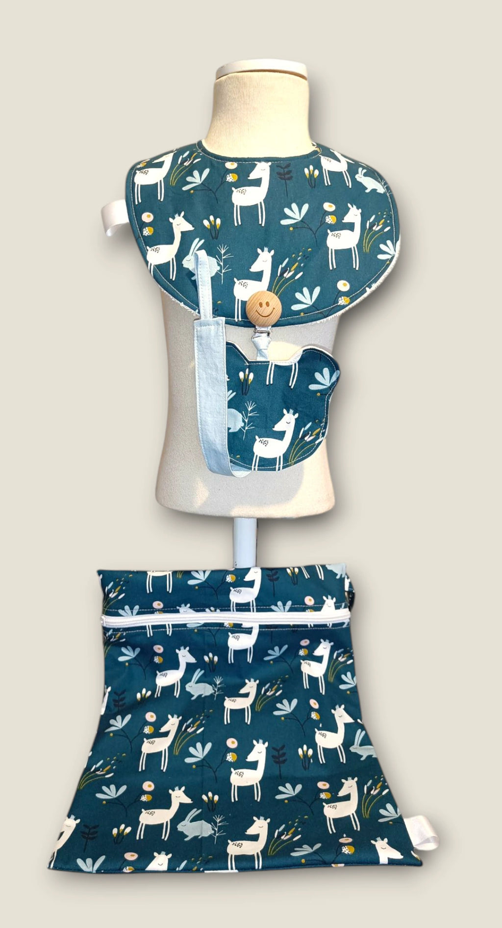 Pack Mini Yo – Esenciales de Bebé Ciervo Flor Azul con babero, chupetero y bolsa impermeable en maniquí.