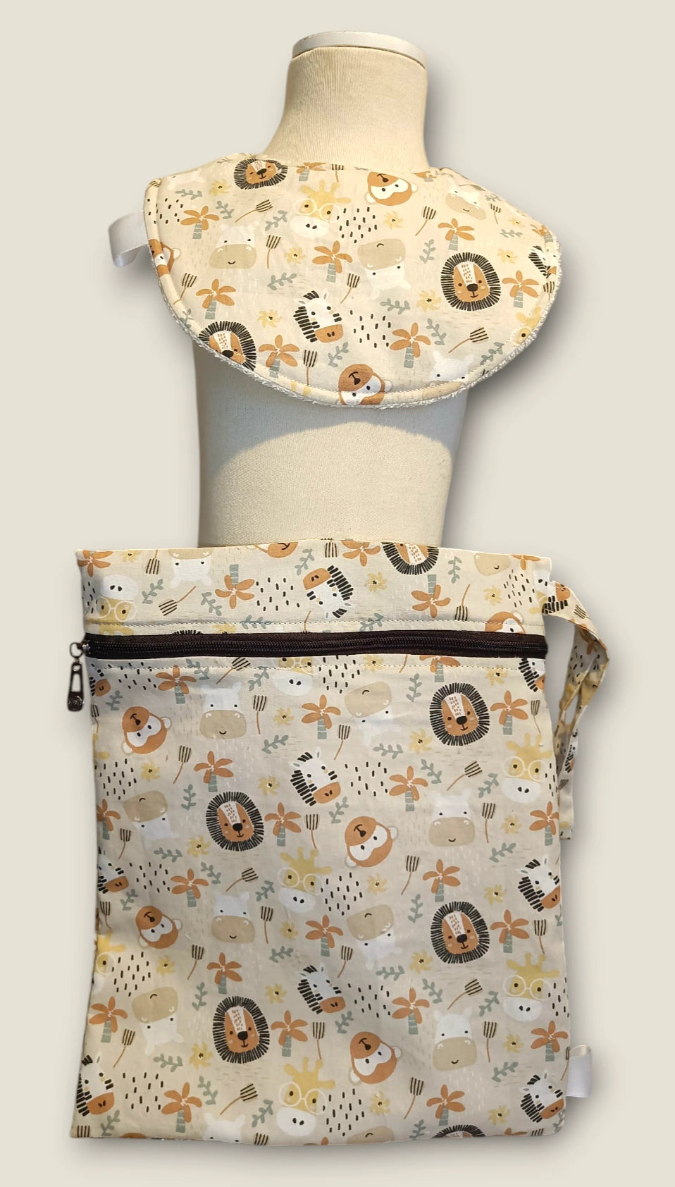 ack Mini Yo – Esenciales de Bebé Sabana con babero impermeable y bolsa impermeable a juego, presentados en maniquí.