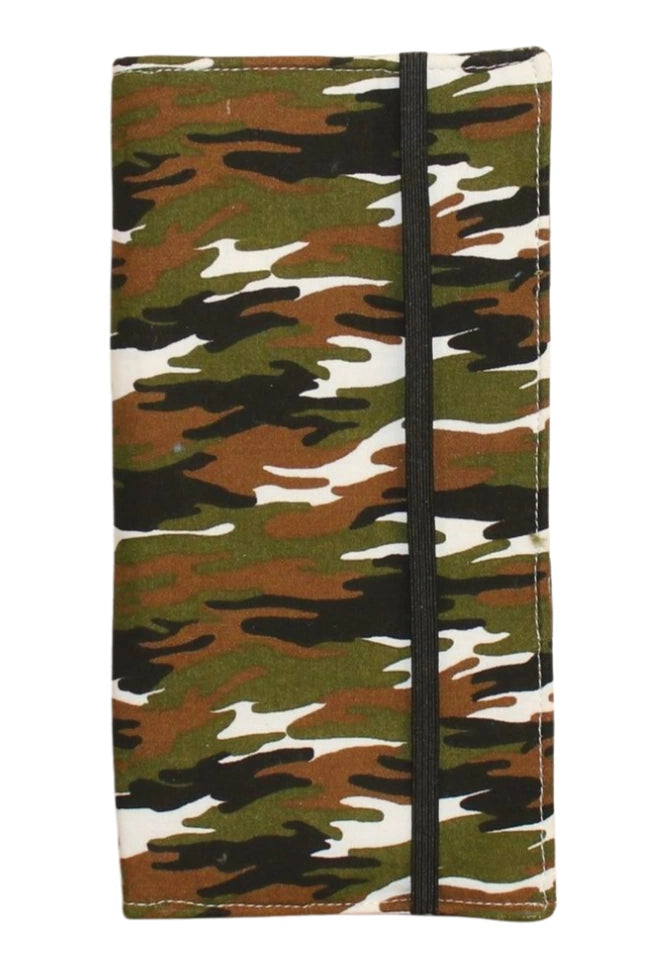 Kit dental infantil cerrado con estampado de camuflaje verde, con goma negra para cierre, sobre fondo beige y globo terráqueo decorativo.