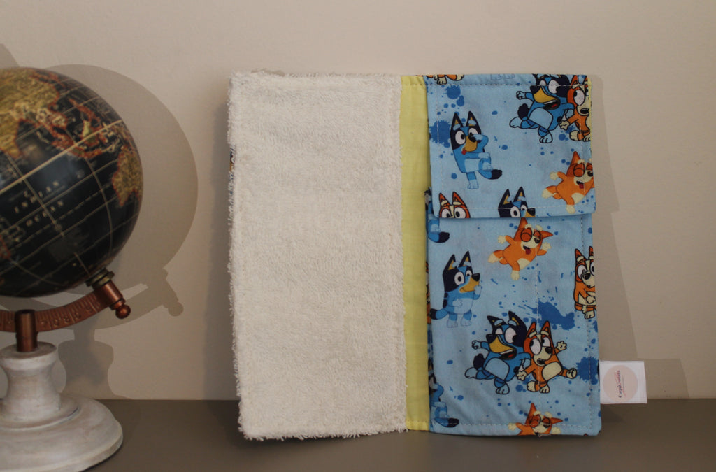 Interior del kit dental infantil de Bluey con bolsillo plastificado y toalla blanca, sobre fondo beige