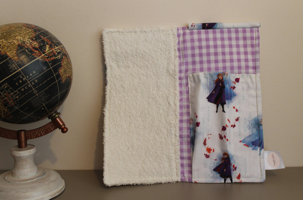 Interior del kit dental infantil con estampado de Frozen, bolsillo con diseño de Anna y fondo vichy lila, junto a un globo terráqueoInterior del kit dental infantil con estampado de Frozen, bolsillo con diseño de Anna y fondo vichy lila, junto a un globo terráqueo