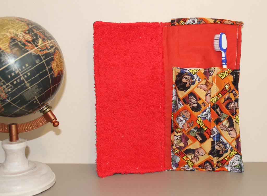 Kit dental infantil de Dragon Ball abierto, con interior rojo y toalla a juego. [variant: Rojo]