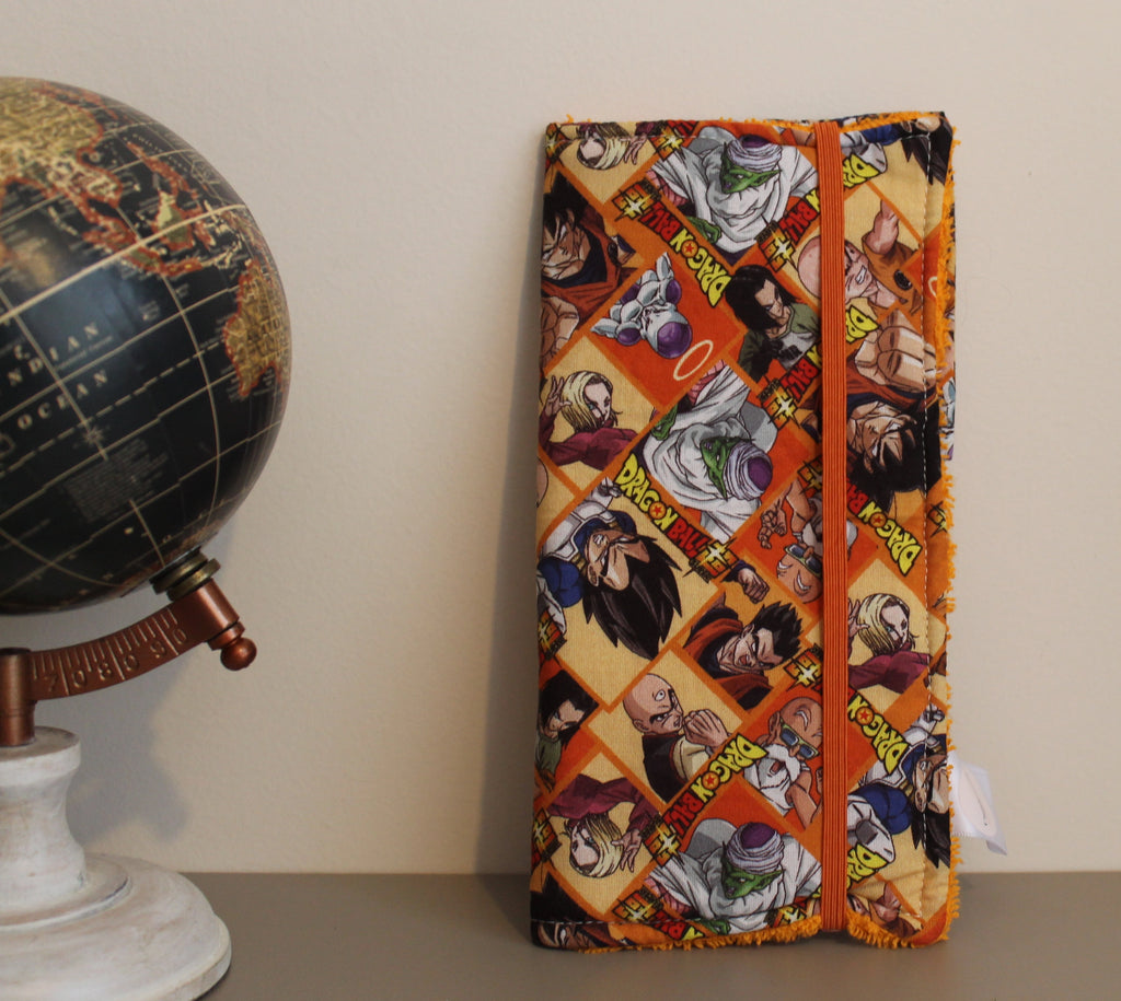 Kit dental de Dragon Ball cerrado con elástico naranja, sobre fondo beige. [variant: Naranja]