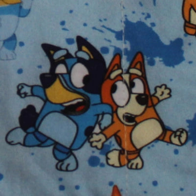 Detalle del estampado infantil de Bluey y Bingo en tonos azul y naranja sobre fondo azul claro