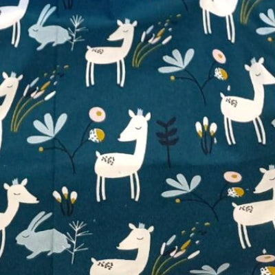 Primer plano de la tela Ciervo Flor Azul con estampado de ciervos blancos, conejitos y flores sobre fondo azul.