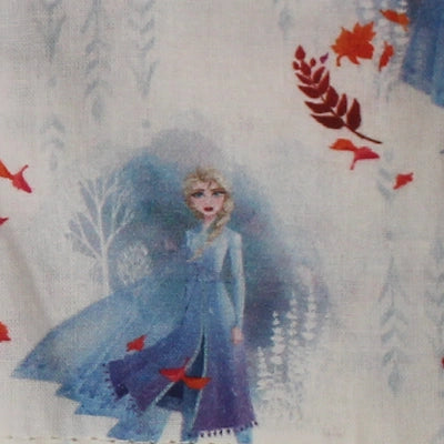 Detalle del estampado infantil de Elsa de Frozen en tonos azules y otoñales sobre fondo blanco