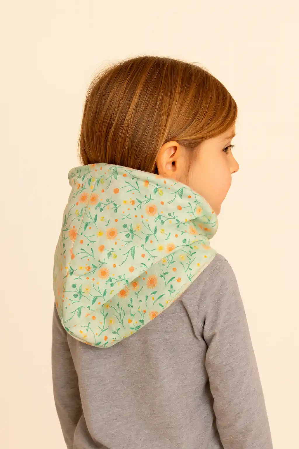 Vista trasera de Buff’n’hood infantil con capucha estampada en flores girasol.